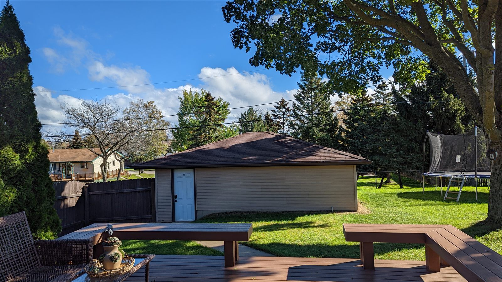 Custom backyard wood deck with built-in bench seating overlooking a fenced yard